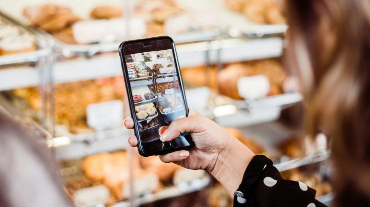 Woman recording a video in a bakery for social networks.