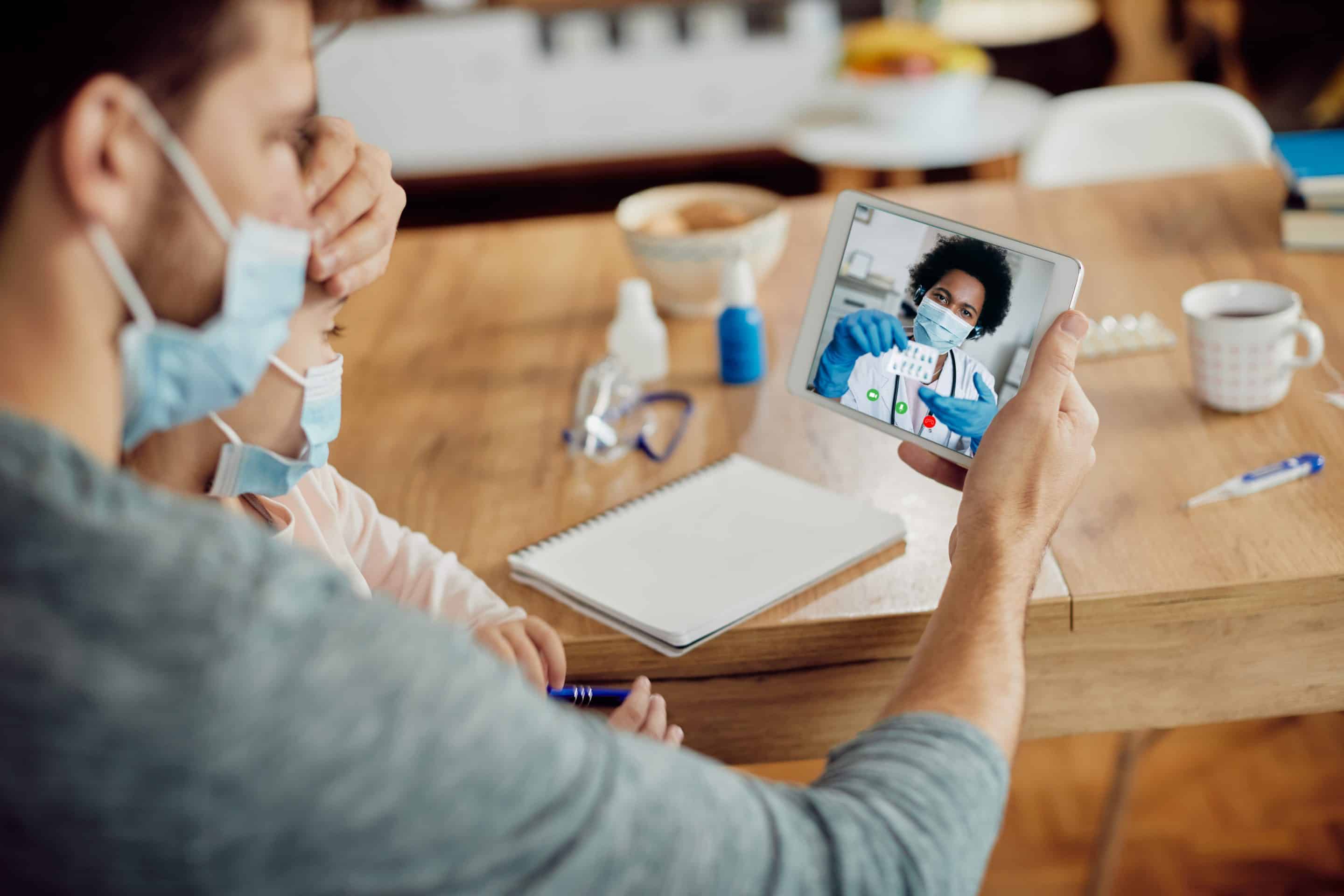 Close-up of father and daughter using touchpad while having vide HealthTech en España: cómo generar confianza y comunicar correctamente