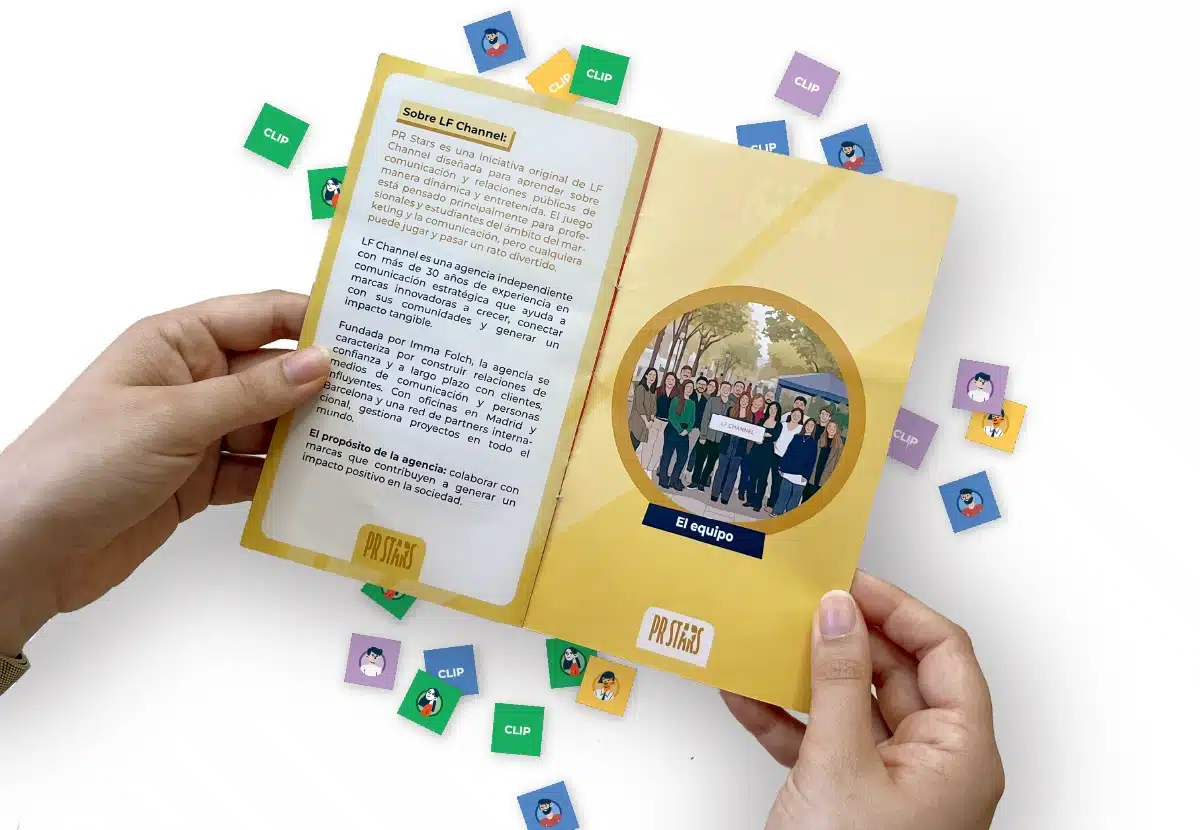imagen_componentes_1200x830 Two hands hold open a yellow-themed mini book: left page has text, right page shows a circular group photo; colorful clip stickers surround the book.